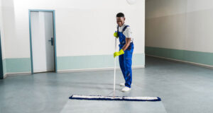 male janitorial staff mopping the floor