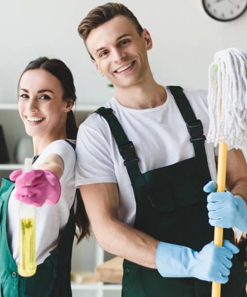 male cleaning staff holding a mop and female staff holding a spray bottle