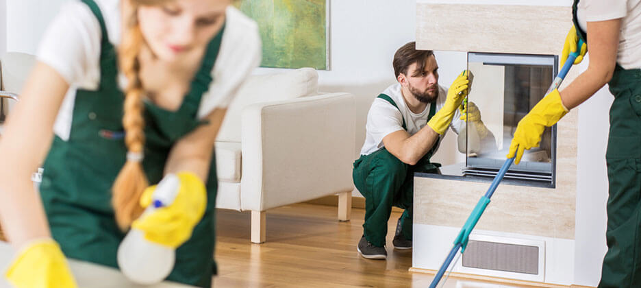 three cleaning staff thoroughly cleaning an office lobby